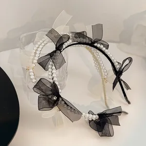 Close-up of dual-row pearls and delicate mesh bows with rhinestones on headbands