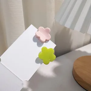 Detail of floral hair claws in pink and lime green on white display card