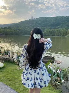 Détail de la pince à cheveux camélia 3D sur un modèle dans un cadre naturel en plein air