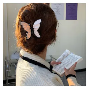 Close-up of a butterfly hair claw clip with heart patterns on a model's hair