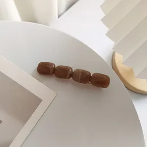 Dettaglio del fermaglio per capelli in acrilico marmorizzato caramello e resina