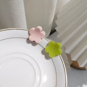 Close-up of pink and green flower hair clips on a white ceramic bowl edge