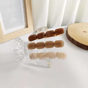 Set di tre fermagli per capelli in acrilico ambra e crema con trama effetto marmo