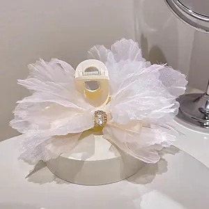 Detalle de pinza para el pelo con lazo de organza blanca y piedra preciosa brillante