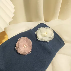 Detail of pink and white chiffon camellia hair clips with elegant pearl centers
