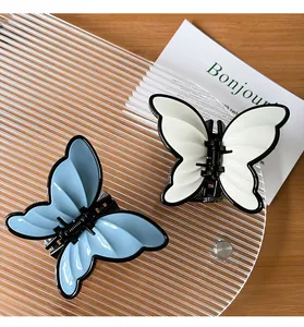 Detail showing light blue and cream butterfly hair claws on a textured tray
