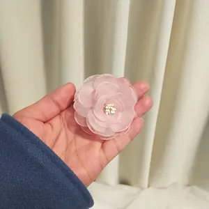 Detailed view of handmade pink chiffon camellia hair clip with layered 3D petals