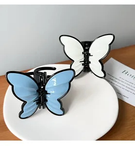 Close-up of elegant blue and white butterfly hair claws on a decorative white plate