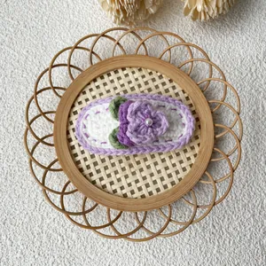 Détail d'une barrette à fleurs au crochet faite main avec perle sur plateau bambou