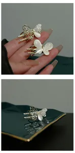 Detail of a small golden butterfly hair clip with rhinestones and opal stone inlay