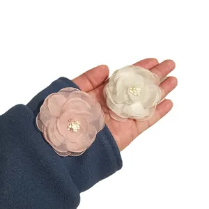 Pink and beige chiffon camellia flower hair clips set shown for size on hand