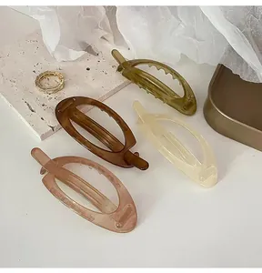 Macro detail of acrylic oval cutout banana clips in four retro elegant colors