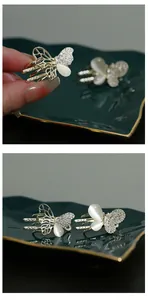 Detail view of silver butterfly hair claw with white opal stones and sparkling rhinestones