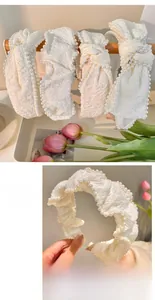 Detail of white fabric headband with faux pearls and bow in elegant French vintage style