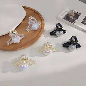 Elegant heart-shaped iridescent pearl hair claw clips in black, white, and champagne colors