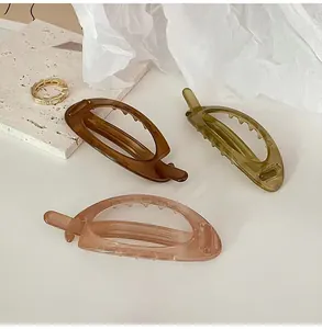 Three acrylic hair clips in brown, green, and pink with a matte finish and non-slip teeth