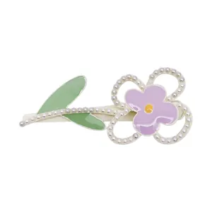 Macaron pink flower hair clip with pearls and green leaves on a clean white background