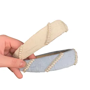 Elegant wide headband with pearls and rhinestones on cream and light blue textured fabric