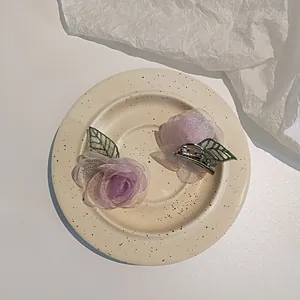 Paire d'élégantes barrettes roses en maille violette avec pétales brillants et feuilles