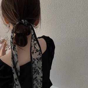 Close-up of black floral lace ribbon tied as a stylish hair accessory on a ponytail
