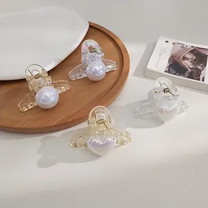 Close-up of pearl hair clips with heart design on an aesthetic wooden background