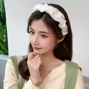 French vintage creamy white pearl headband with elegant pleated bow on a model