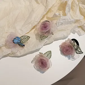 Détail du lot de quatre barrettes camélia et chouchous en tulle rose avec paillettes