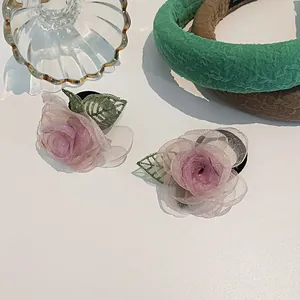 Détail de chouchous camélia rose avec tissu en maille superposé et élastique
