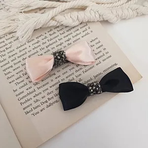 Elegant set of satin bow hair clips in pink and black with sparkling rhinestone accents