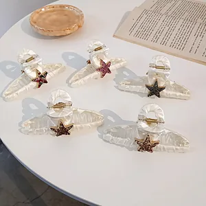 Lot de 5 grandes pinces à cheveux en tissu avec étoiles en strass colorées sur table