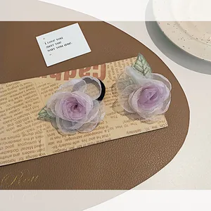 Deux chouchous camélia en organza violet avec paillettes argentées et feuilles en mesh