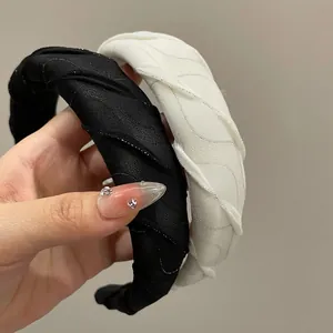 Detail of black and white sparkling mesh headbands with pleated wavy fabric texture