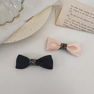 Elegant set of pink and black satin bow hair clips with sparkling rhinestone center