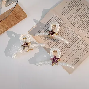 Détail de pinces à cheveux étoiles en strass avec texture ondulée sur un livre