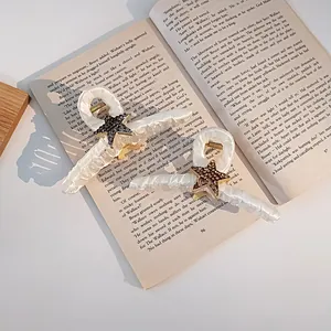 Détail macro de pinces à cheveux étoile avec strass sur un livre ouvert avec lumière douce