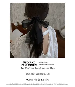 Detail view of 26cm black satin bow scrunchie showing fine texture and 5g lightweight design