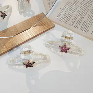 Détail de pinces à cheveux en tissu avec sequins en étoile brillants sur un livre