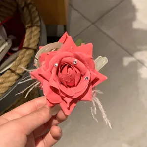 Pince à cheveux avec rose rose, plumes et strass pour une coiffure élégante