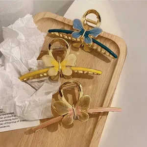 Three-piece vintage metal butterfly hair claws with colorful enamel finish on wood