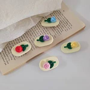 Detailed macro shot of vintage matte 3D rose hair clips in five assorted colors