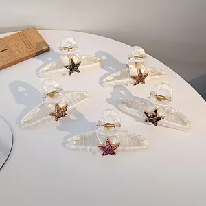 Détail de cinq pinces à cheveux en tissu avec étoiles noires, dorées et roses