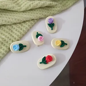 Close-up of five colorful 3D rose hair clips in blue pink purple yellow and red