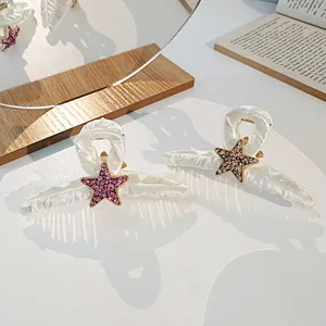Gros plan sur les pinces à cheveux en tissu avec motifs étoiles en strass sur bois