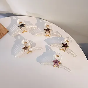 Détail de cinq pinces à cheveux crème avec étoiles en strass de diverses couleurs