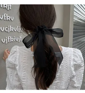 Elegant black organza bow hair tie shown on a ponytail with a stylish long ribbon design