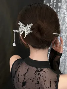 Macro view of silver butterfly hair pin with lily of the valley tassel on dark bun