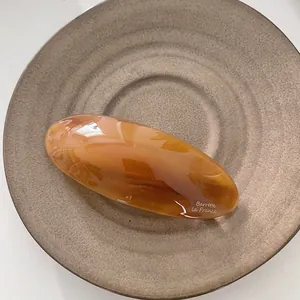Primer plano de un pasador de resina ámbar en un plato de cerámica de estilo retro