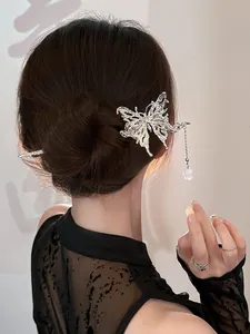 Detail of silver butterfly hair pin with tassel and pearl pendant on a low bun