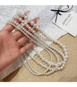 Detalle de collar de perlas blancas de varias capas con acabado brillante y diseño elegante
