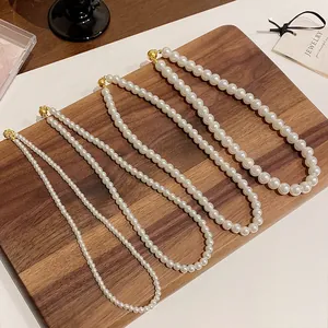 Set de cuatro collares de perlas francesas elegantes con cierres dorados en madera